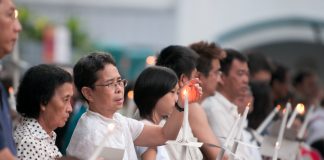 Congregants light candles at St. Joseph's Church in Singapore