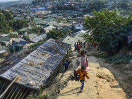 A Rohingya refugee boy carries a chicken as he walks back to his makeshift house in Jamtoli refugee camp | LiCAS News