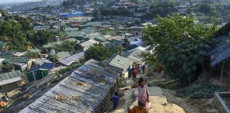 A Rohingya refugee boy carries a chicken as he walks back to his makeshift house in Jamtoli refugee camp | LiCAS News