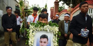 A family member carries a portrait Hoang Van Tiep