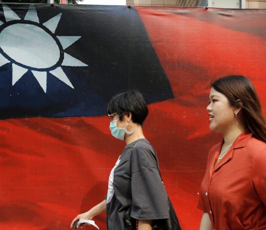 People walking past a Taiwan flag in Taipei
