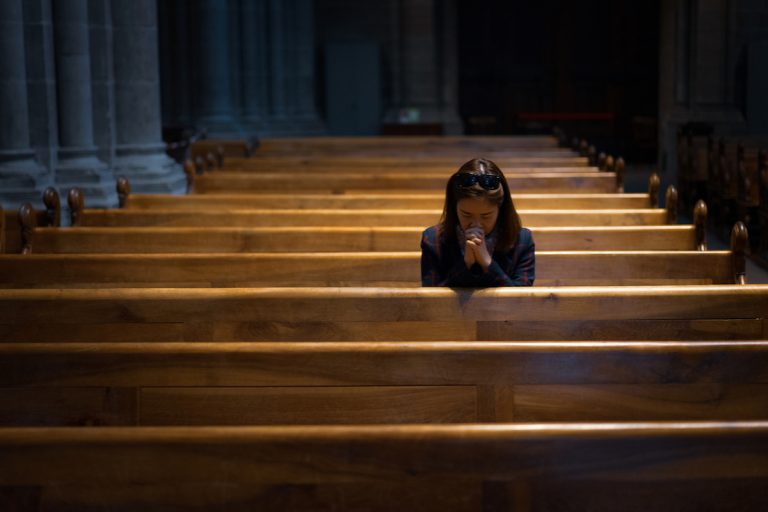One woman praying in empty church