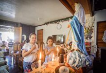 Children join a family prayer before the image of the Blessed Virgin Mary