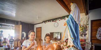 Children join a family prayer before the image of the Blessed Virgin Mary