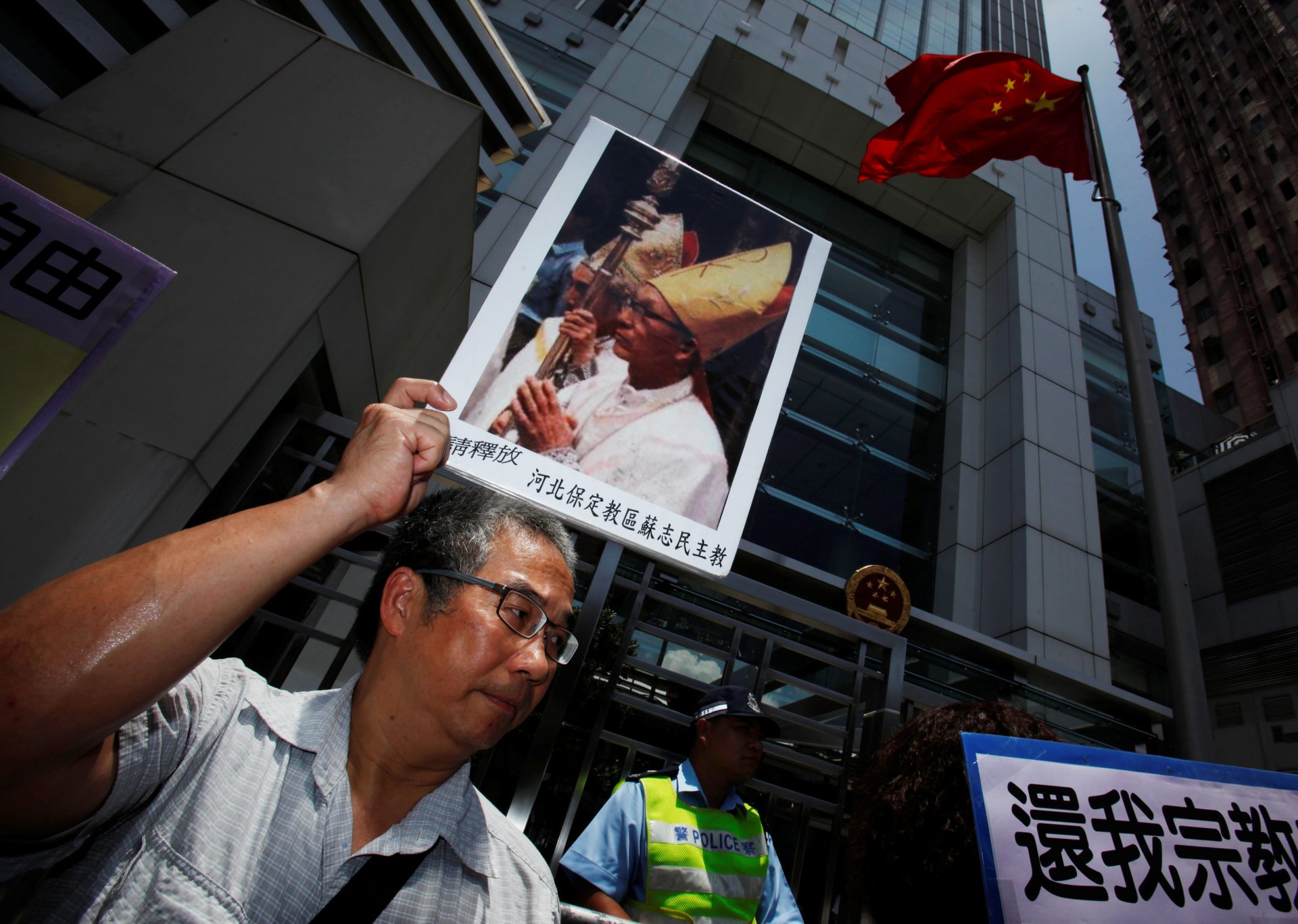 A protester carries a portrait of Bishop Su Zhi-ming of Baoding, Hebei province