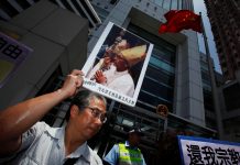 A protester carries a portrait of Bishop Su Zhi-ming of Baoding, Hebei province
