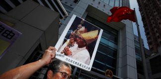 A protester carries a portrait of Bishop Su Zhi-ming of Baoding, Hebei province