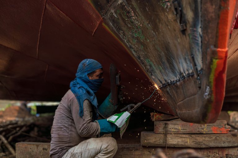 Worker breaking up a ship in Dhaka