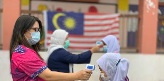 Students have their temperature taken at a school in Malaysia