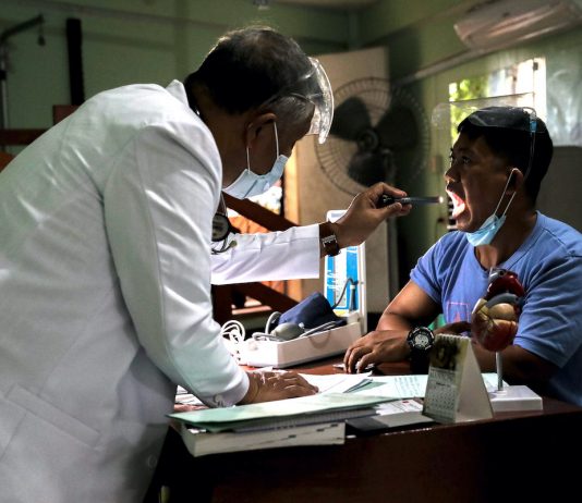 Doctor using a flash light to examine a patient
