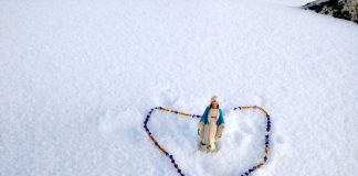 Statue of Virgin Mary and Rosary with snow in the background at the top of Mount Everest