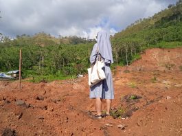 A nun standing among cyclone desvasted landscape | LiCAS.news
