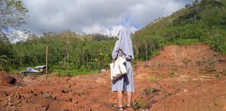 A nun standing among cyclone desvasted landscape | LiCAS.news