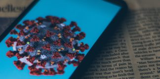 Coronavirus on phone screen on top of a book