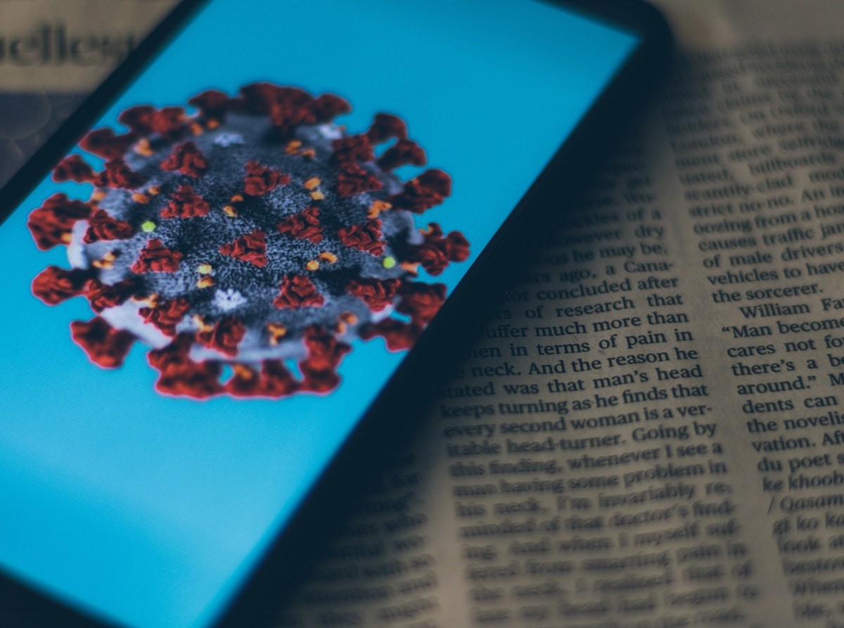 Coronavirus on phone screen on top of a book