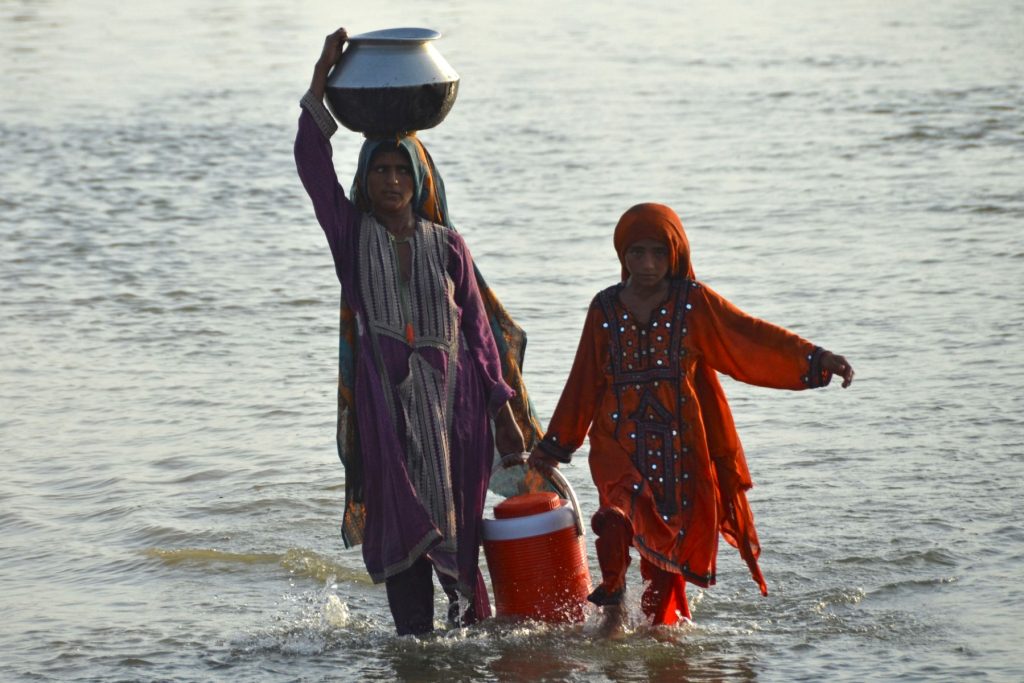 Flood affected women carry drinking water in containers (Pakistan)