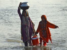 Flood affected women carry drinking water in containers (Pakistan)