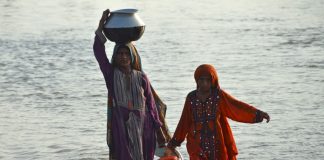 Flood affected women carry drinking water in containers (Pakistan)