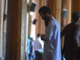A muslim man praying in a mosque (side profile)