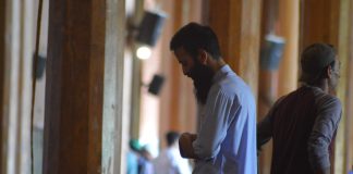 A muslim man praying in a mosque (side profile)