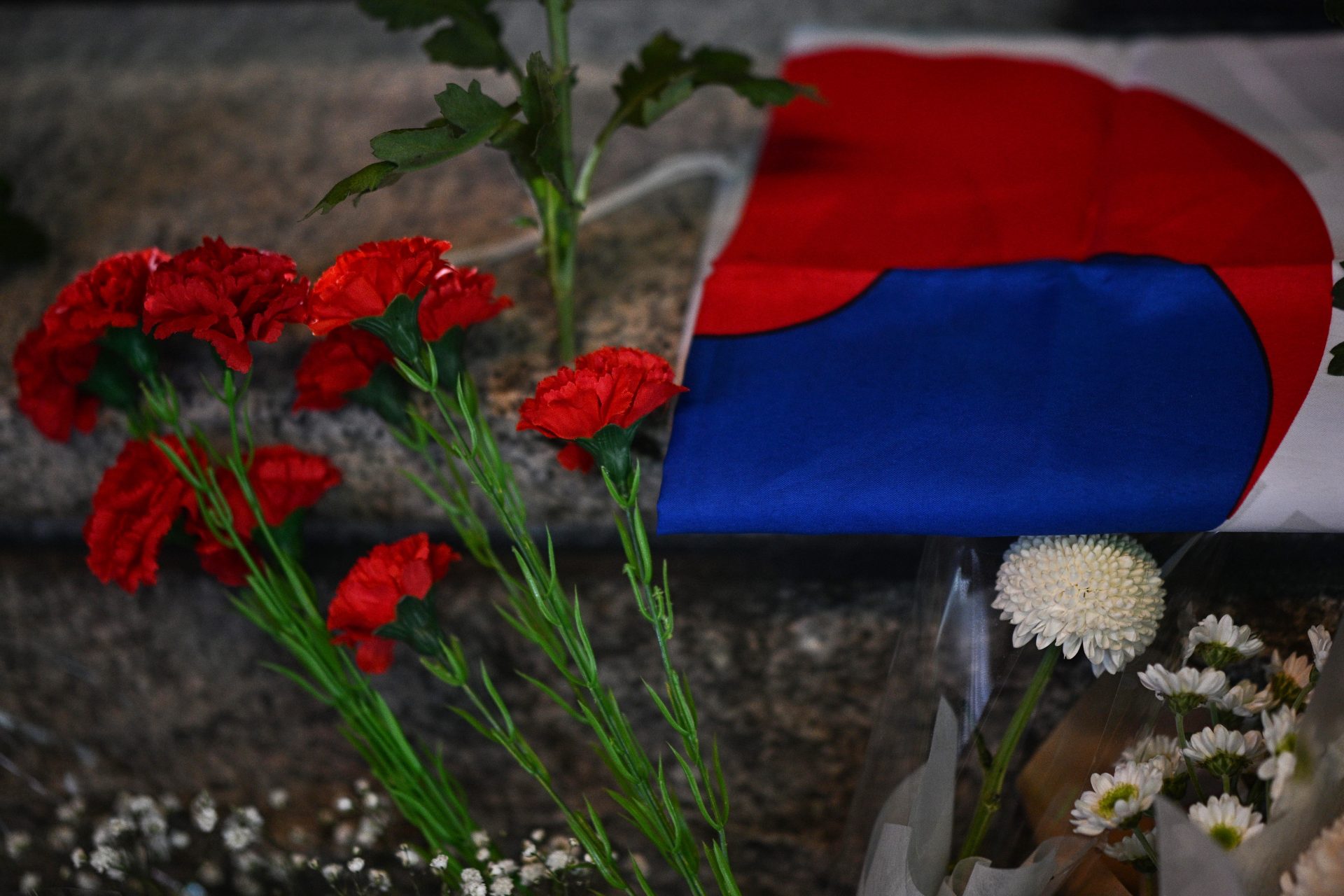 Korean flag next to mourning flowers