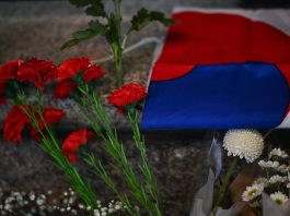 Korean flag next to mourning flowers