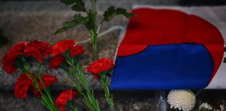 Korean flag next to mourning flowers