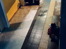 A beggar on an empty pavement in Bangkok, Thailand