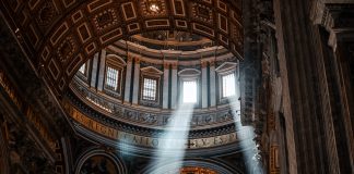 The dome of St. Peter's Basilica with rays of light shining through the windows