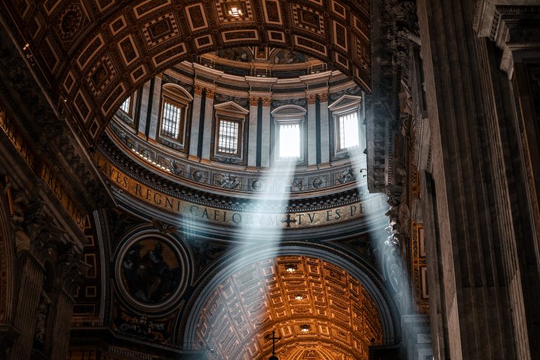 The dome of St. Peter's Basilica with rays of light shining through the windows