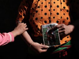 Close up photo of a Vietnamese mother holding a photo of her missing daughter