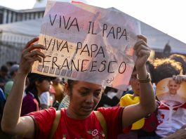 A woman holding up the sign "Viva Il Papa" while waiting for Pope Francis in Indonesia