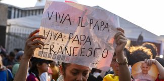 A woman holding up the sign "Viva Il Papa" while waiting for Pope Francis in Indonesia