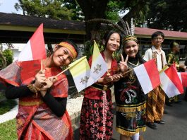 Children waving Vatican and Indonesian flags