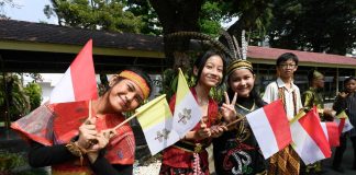 Children waving Vatican and Indonesian flags