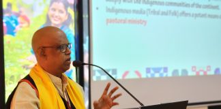 Fr. Vincent Wilson speaking at a podium in Nepal
