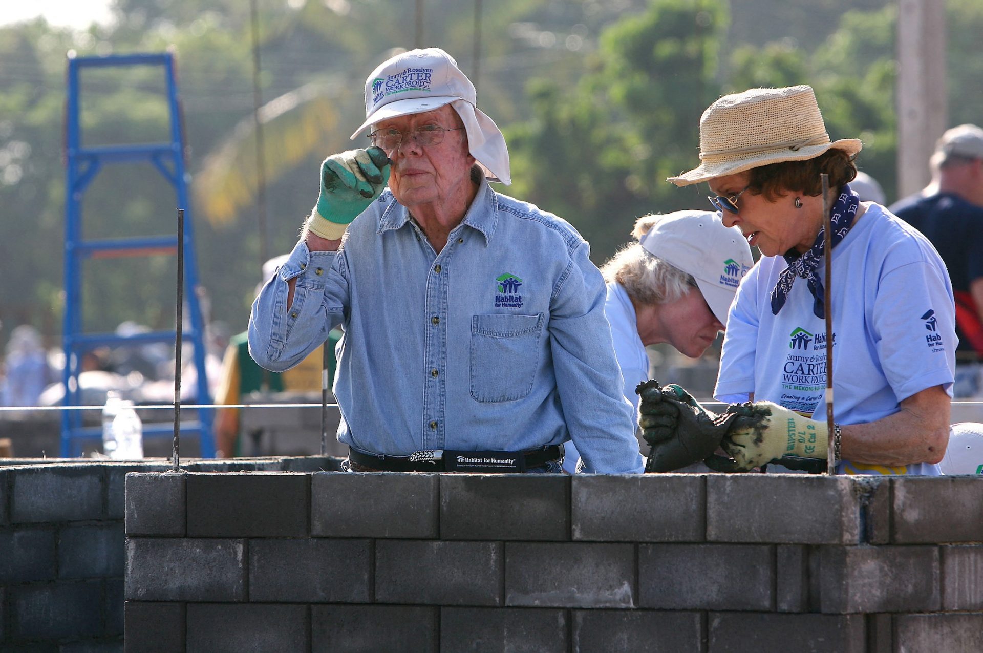 President Jimmy Carter and wife Rosalynn working on a building site in the sun.