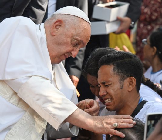 Pope Francis blessing a child in Dili
