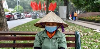 A worker uses a smartphone at a park in Hanoi