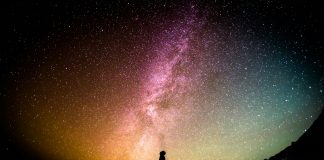 A human standing looking up at the Milky Way.