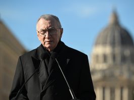 The Vatican's Cardinal Secretary of State Pietro Parolin speaking in front of St. Peter's Basilica visible as a blurry background