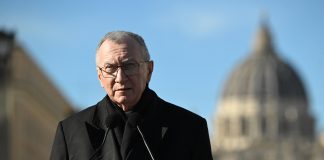 The Vatican's Cardinal Secretary of State Pietro Parolin speaking in front of St. Peter's Basilica visible as a blurry background